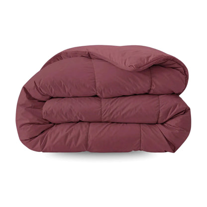 De Zelesta Pure Uni Dekbed Katoen in bordeaux rood, met een doorgestikt dessin, wordt getoond opgevouwen tegen een witte achtergrond - perfect voor optimaal slaapcomfort.