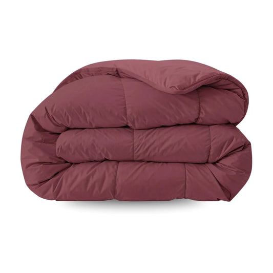 De Zelesta Pure Uni Dekbed Katoen in bordeaux rood, met een doorgestikt dessin, wordt getoond opgevouwen tegen een witte achtergrond - perfect voor optimaal slaapcomfort.