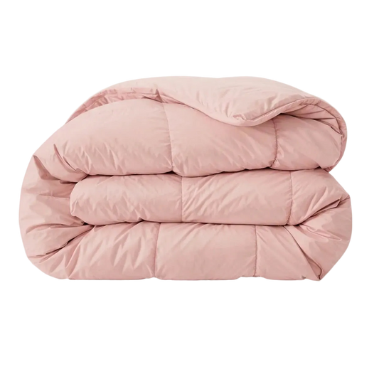 Een gevouwen Zelesta Pure Uni Dekbed Katoen in zachtroze, met zichtbare stiksels voor ademend slaapcomfort, tegen een effen witte achtergrond.