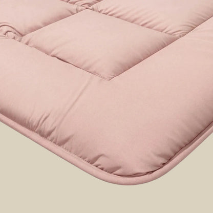 Close-up van de Zelesta Pure Uni Dekbed Katoen in zachtroze, met doorgestikte stiksels en een gewatteerde textuur voor geavanceerd slaapcomfort, ideaal om te combineren met duurzaam beddengoed.