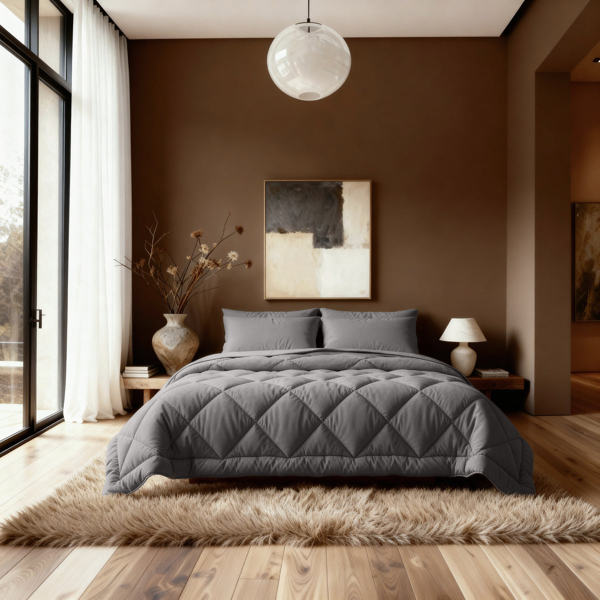 Een moderne slaapkamer met het Zelesta Comfort Uni diamond Dekbed in bruin-grijs, abstract kunstwerk op een bruine muur, groot raam met witte gordijnen en houten vloeren met een shaggy vloerkleed.