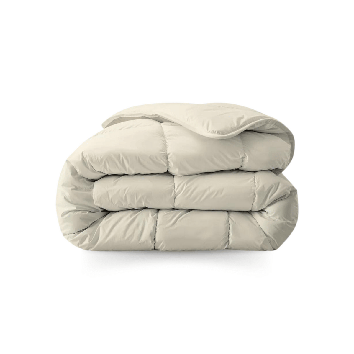 Een netjes opgevouwen, lichtbeige dekbed van zachte, doorgestikte stof op een witte ondergrond - een Zelesta Royalbed - Sand Beach dekbed en overtrek in één voor comfort het hele jaar door.