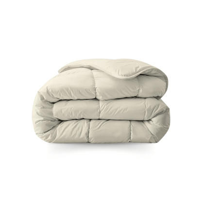 Een netjes opgevouwen, lichtbeige dekbed van zachte, doorgestikte stof op een witte ondergrond - een Zelesta Royalbed - Sand Beach dekbed en overtrek in één voor comfort het hele jaar door.