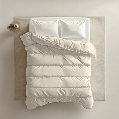 Een keurig opgemaakt bed met twee witte kussens en een zandkleurig Zelesta Royalbed - Sand Beach staat op een licht vloerkleed naast een klein houten nachtkastje met een vaas.