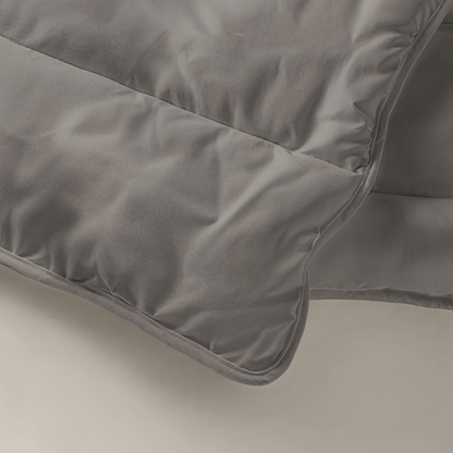 Een close-up van het Tender Grey Zelesta Royalbed benadrukt de gladde gewatteerde stof en de gedetailleerde stiksels - perfect als dekbed en overtrek in één.