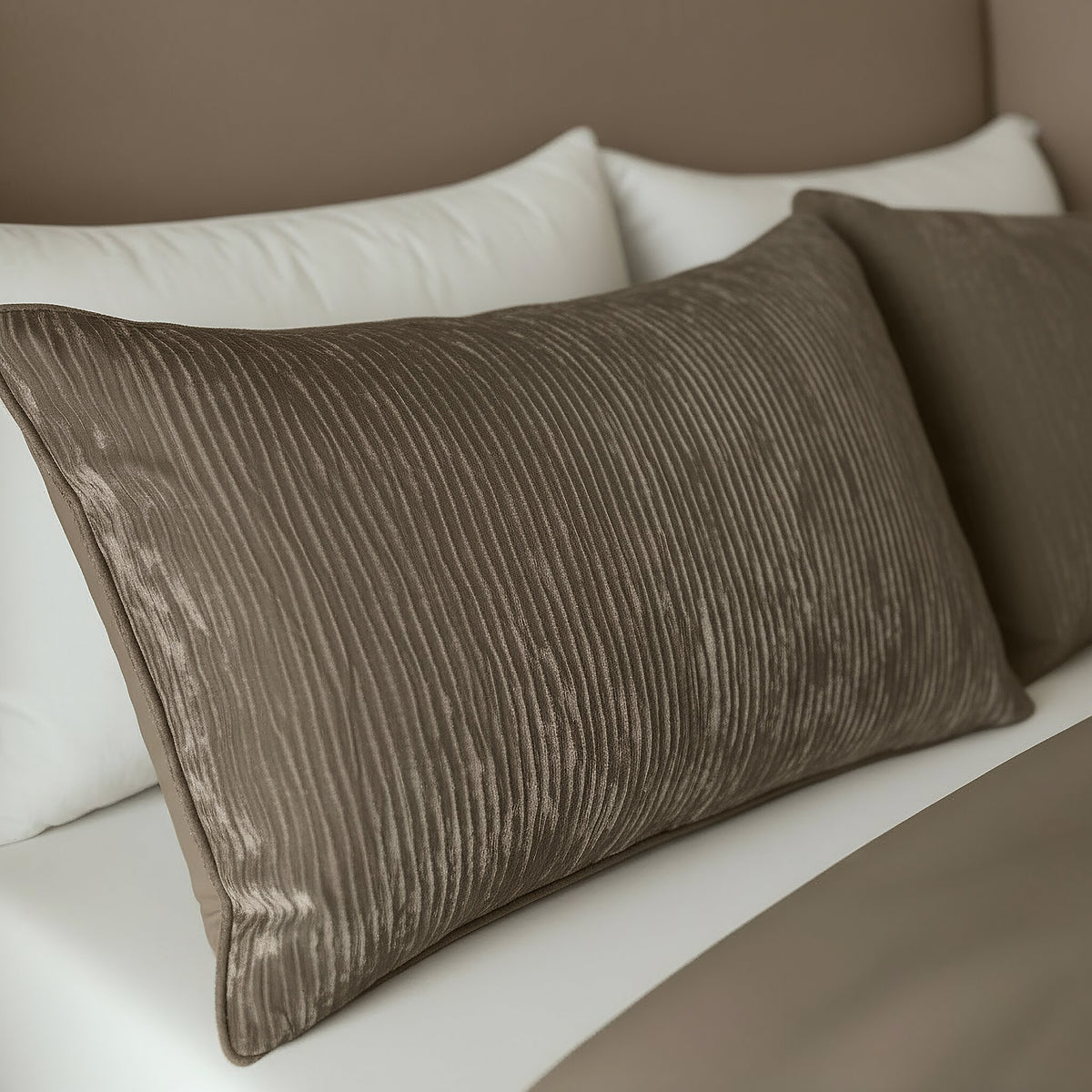 Een close-up van een netjes opgemaakt bed met twee Zelesta Velvetbed Chique Kussensloop Set van 2 - Taupe sierkussenhoezen van 100% structuurpolyester, geplaatst voor witte kussens.
