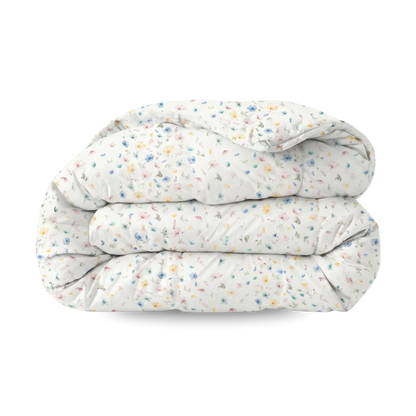 Het Zelesta Wonderbed - Spring Bloom is een gevouwen wit dekbed met een kleine, veelkleurige bloemenprint op een effen achtergrond, die anti-allergie comfort combineert met stijlvol design.