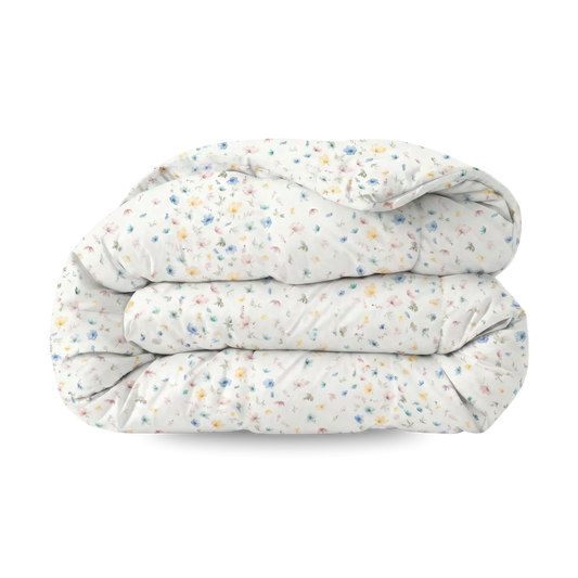 Het Zelesta Wonderbed - Spring Bloom is een gevouwen wit dekbed met een kleine, veelkleurige bloemenprint op een effen achtergrond, die anti-allergie comfort combineert met stijlvol design.