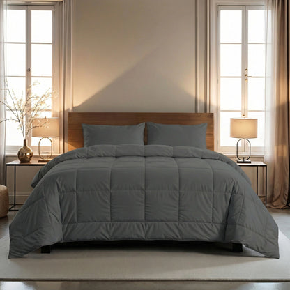 Een netjes opgemaakt bed met het Zelesta Wonderbed 4 Seasons Double - Stone Grey dekbed en bijpassende kussens is gecentreerd tussen twee ramen en biedt temperatuurregulerend comfort. Nachtkastjes en lampen staan aan weerszijden.