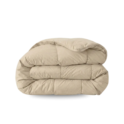 Een Zelesta Wonderbed - Warm Sand dekbed, beige met een doorgestikt dessin, anti-allergisch en wasbaar, is opgevouwen en geplaatst op een effen witte ondergrond.