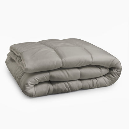 Een netjes opgevouwen, teder grijs Zelesta Royalbed all-season dekbed wordt getoond tegen een effen witte achtergrond.