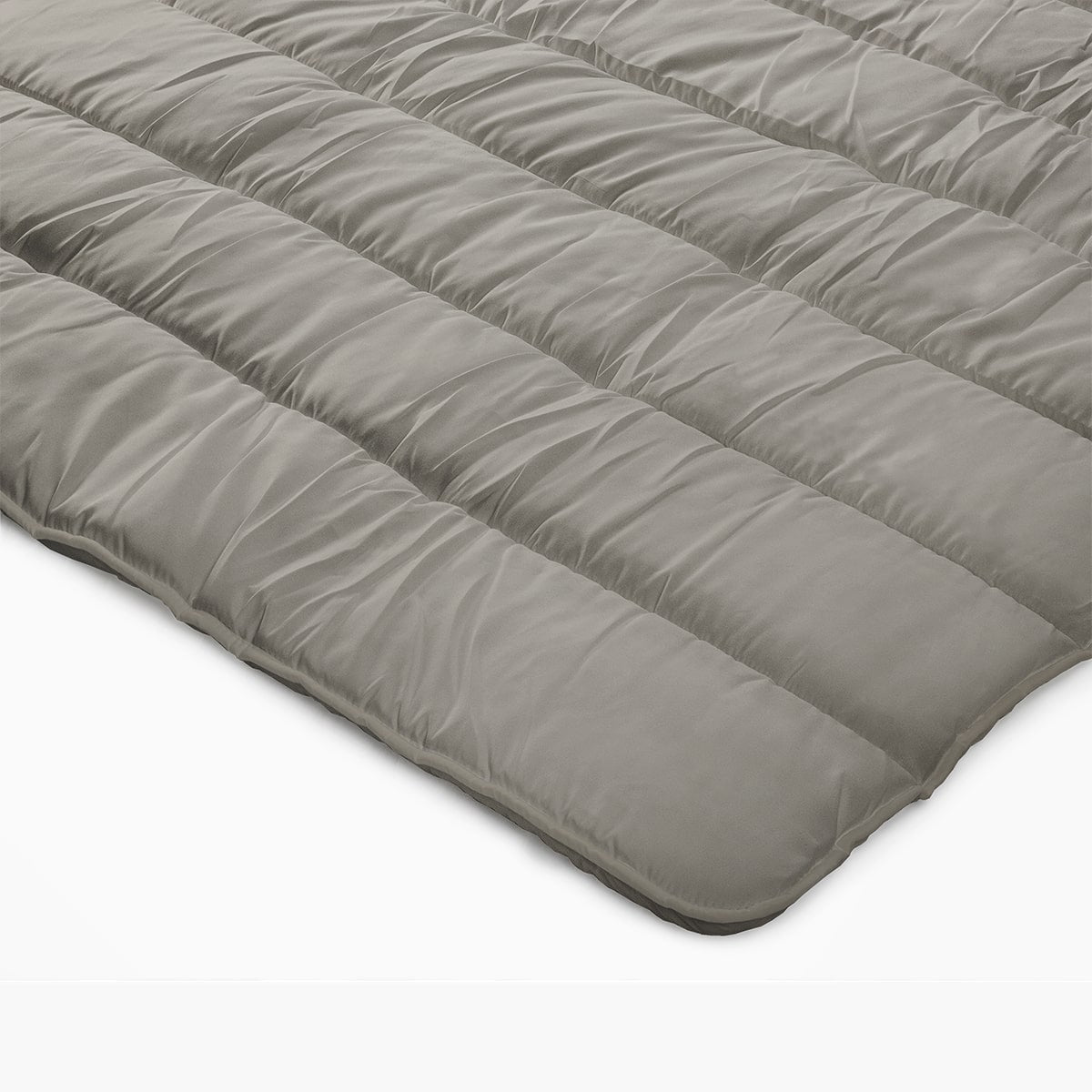 Een close-up van het Zelesta Royalbed - Tender Grey, een dekbed en overtrek voor alle seizoenen in één, met een grijs gewatteerd dekbed plat gelegd op een witte ondergrond.