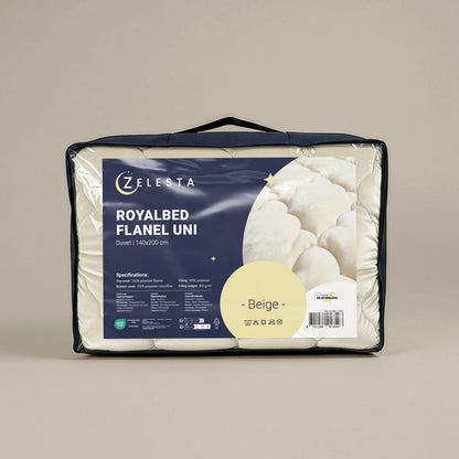 Een Zelesta Flanel Uni - Beige dekbed van 140x200 cm staat rechtop verpakt, met productinformatie en specificaties duidelijk zichtbaar op het voorlabel.