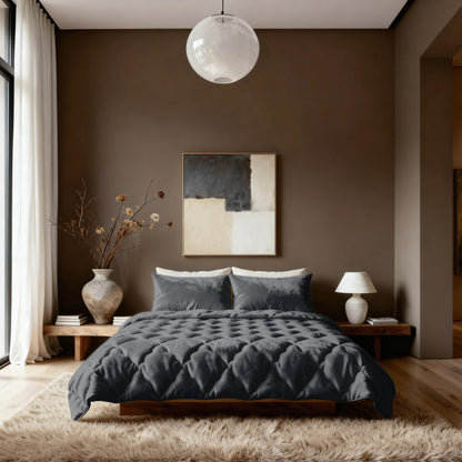 Een moderne slaapkamer met het Zelesta Flanel Uni - Zwart 2-in-1 dekbed op een laag houten bed, met beige muren, een groot abstract schilderij, vazen met gedroogde takken, een tafellamp en een ronde plafondlamp boven een pluche vloerkleed.