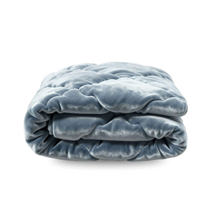 Het Zelesta Flanel Uni - Blue Mirage, een zacht, gewatteerd blauw flanel gedekt met een fluweelachtige textuur, wordt getoond tegen een witte achtergrond.