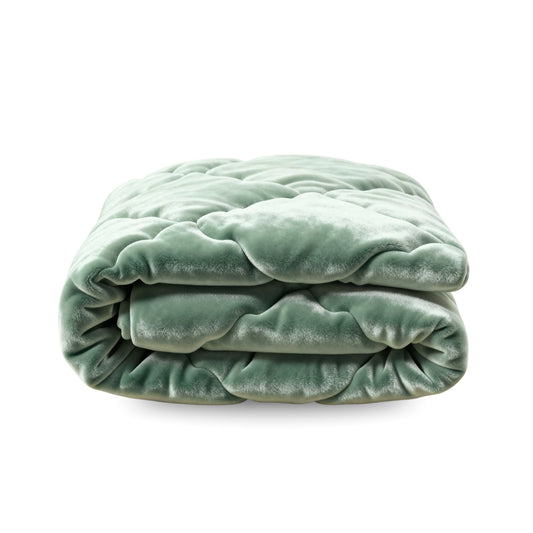 Het Zelesta Flanel Uni in groen is een netjes gevouwen, fluweelzacht flanel dekbed of deken met een zachte, pluche textuur, tegen een witte achtergrond.