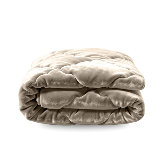 Het Zelesta Flanel Uni - Taupe is een pluche, netjes gevouwen beige dekbed met een doorgestikte textuur, afgebeeld op een witte achtergrond. Dit temperatuurregulerende 2-in-1 dekbed biedt comfort en veelzijdigheid voor gebruik het hele jaar door.