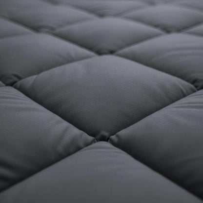Close-up van het Zelesta Comfort Uni diamond Dekbed - Antraciet met een donkergrijze gewatteerde stof met vierkante stiksels, ideaal voor gebruik als comfort- of all-season dekbed.