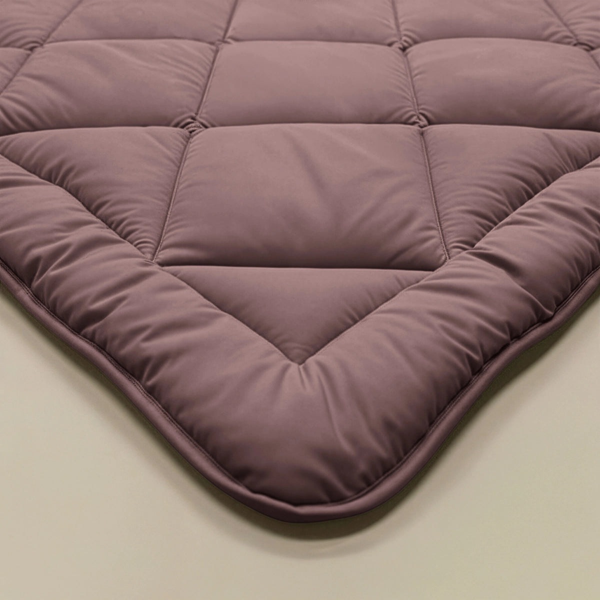 Close-up van het Zelesta Comfort Uni diamond Dekbed - Bordeaux, met een gewatteerd, doorgestikt ontwerp met vierkante stiksels en gladde textuur - ideaal als klassiek dekbed of vast overtrek.