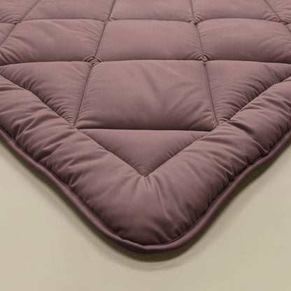 Close-up van het Zelesta Comfort Uni diamond Dekbed - Bordeaux, met een gewatteerd, doorgestikt ontwerp met vierkante stiksels en gladde textuur - ideaal als klassiek dekbed of vast overtrek.