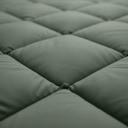Close-up van het Zelesta Comfort Uni diamond Dekbed - Groen, met het groen gewatteerde oppervlak met vierkante gewatteerde delen en zichtbare stiksels, dat doet denken aan klassieke dekbedden voor gebruik met een vaste overtrek.