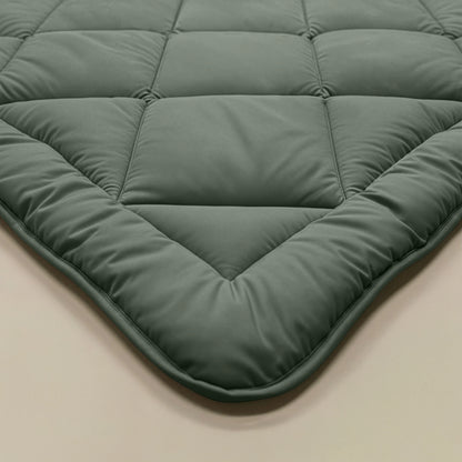Close-up van een hoek van het Zelesta Comfort Uni diamond Dekbed in groen, met het doorgestikte ontwerp en de zachte, gladde textuur die doet denken aan klassieke dekbedden.