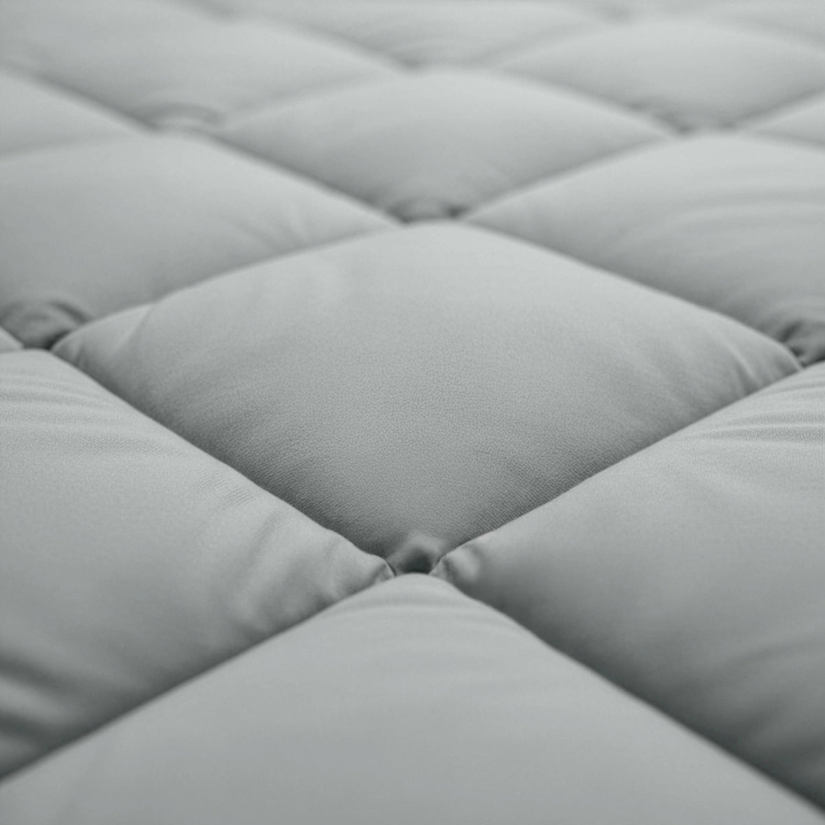 Close-up van het Zelesta Comfort Uni diamond Dekbed in grijs-blauw. De gewatteerde stof met vierkante stiksels doet denken aan klassieke dekbedden uit de Comfort-lijn.