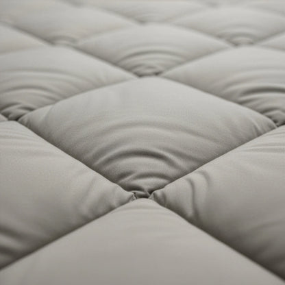 Close-up van het Zelesta Comfort Uni diamond Dekbed - Zandbeige, met gewatteerde, gewatteerde stof met ruitvormige stiksels en zachte, verhoogde delen geïnspireerd op klassieke dekbedden.