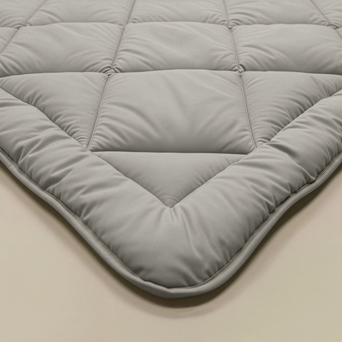 Close-up van het Zelesta Comfort Uni diamond Dekbed in zandbeige, met gewatteerde stiksels en gewatteerde delen, plat neergelegd.