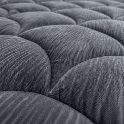 Close-up van het Zelesta Flanel Velvet Bed Chique in Antraciet: het grijze, gewatteerde oppervlak heeft afgeronde, gewatteerde delen in een stijlvol herhalend patroon.