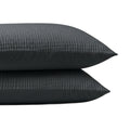 De Zelesta Velvetbed Chique Kussensloop Set van 2 in antraciet heeft donkergrijze, verticaal gestreepte kussenslopen gemaakt van 100% polyester fluweel voor een zacht, comfortabel gevoel, afgebeeld gestapeld tegen een effen witte achtergrond.