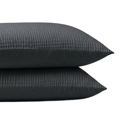 De Zelesta Velvetbed Chique Kussensloop Set van 2 in antraciet heeft donkergrijze, verticaal gestreepte kussenslopen gemaakt van 100% polyester fluweel voor een zacht, comfortabel gevoel, afgebeeld gestapeld tegen een effen witte achtergrond.