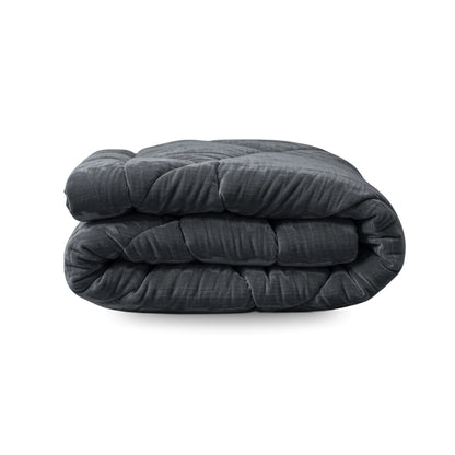 Het Zelesta Flanel Velvetbed Chique in antraciet, met een doorgestikte fluwelen textuur, wordt getoond opgevouwen tegen een witte achtergrond.