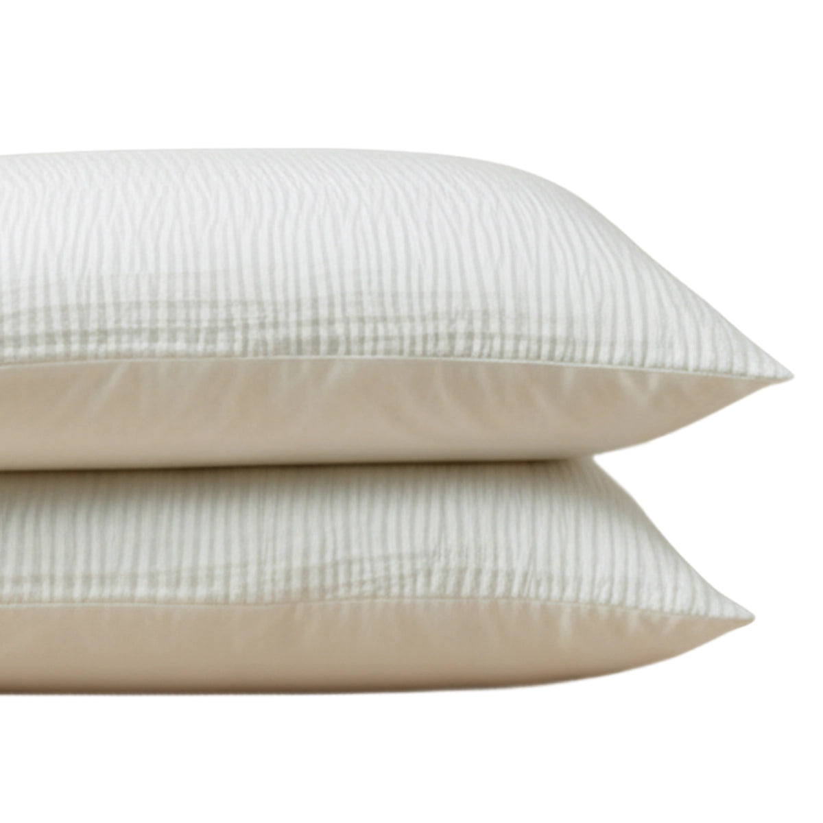 Het Zelesta Velvetbed Chique Kussensloop Set van 2 in beige, gemaakt van 100% polyester, heeft subtiele strepen - perfect voor een comfortabel nachtrust. Twee crèmekleurige kussenslopen zijn gestapeld tegen een witte achtergrond.