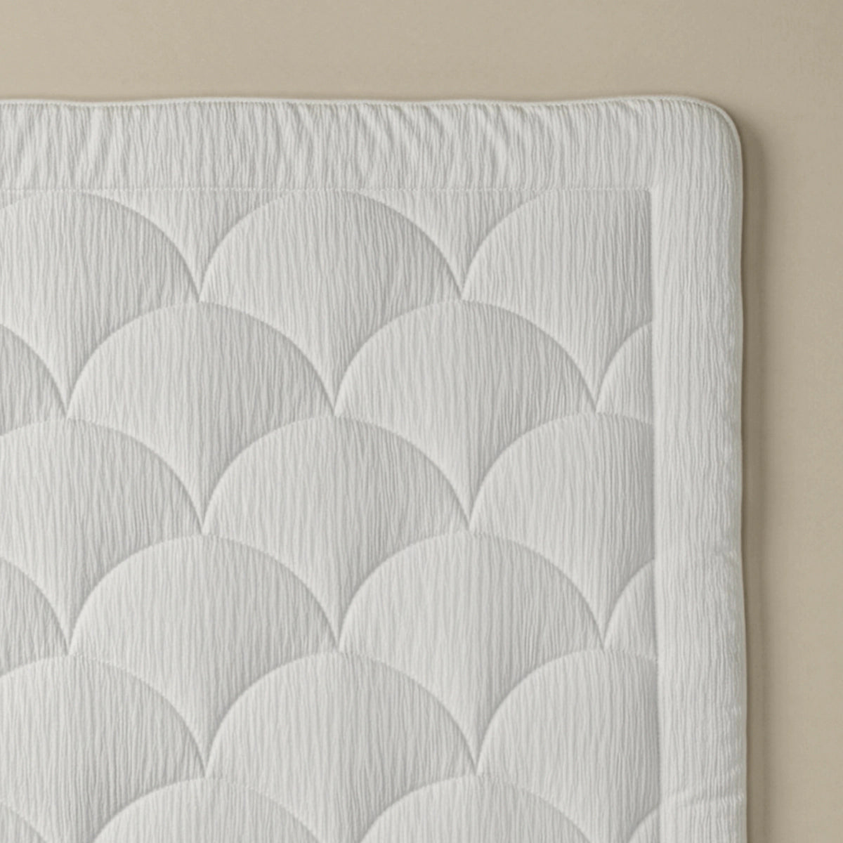 Een close-up van het Zelesta Flanel Velvetbed Chique in beige, met een doorgestikt dessin met Jacobsschelpmotief tegen een beige achtergrond.
