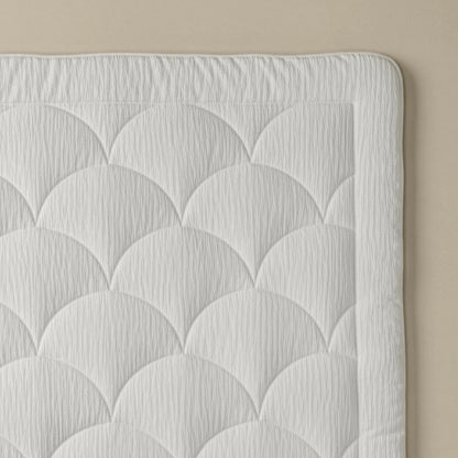 Een close-up van het Zelesta Flanel Velvetbed Chique in beige, met een doorgestikt dessin met Jacobsschelpmotief tegen een beige achtergrond.