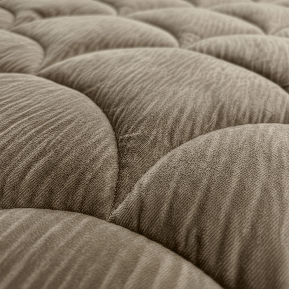 Close-up van het Zelesta Flanel Velvetbed Chique in taupe, met zijn beige, gewatteerde stoffen oppervlak met gewatteerde, getufte textuur voor een luxe uitstraling.
