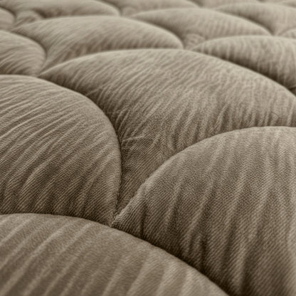 Close-up van het Zelesta Flanel Velvetbed Chique in taupe, met zijn beige, gewatteerde stoffen oppervlak met gewatteerde, getufte textuur voor een luxe uitstraling.