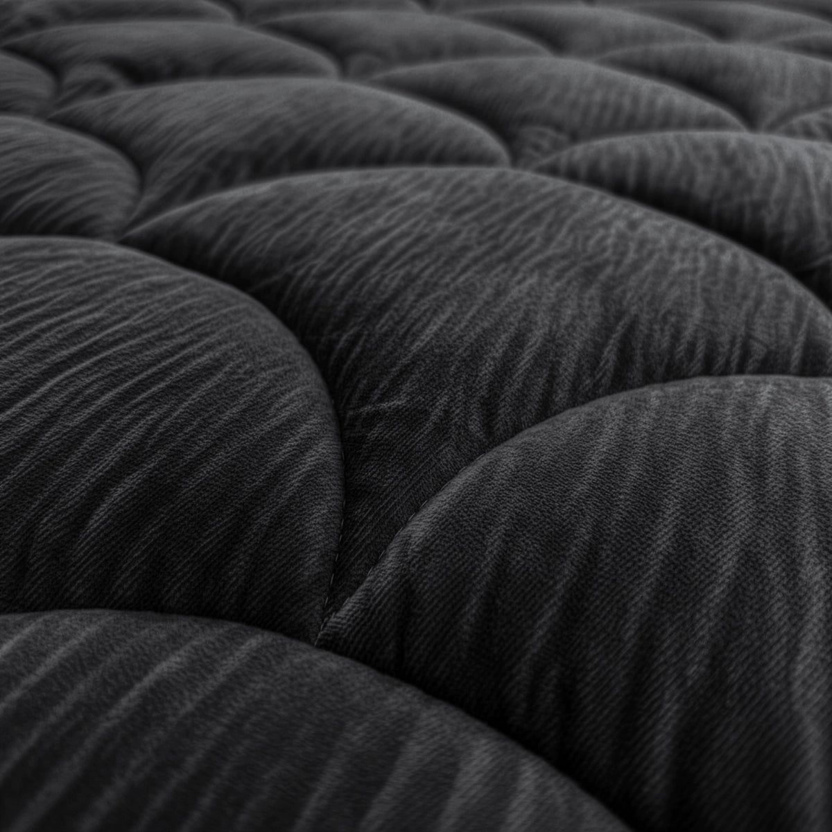 Close-up van het Zelesta Flanel Velvetbed Chique - Zwart, met de nadruk op het donkere, gewatteerde fluwelen oppervlak met afgeronde hoeken en een structuurpatroon voor een luxe uitstraling.
