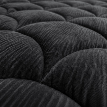 Close-up van het Zelesta Flanel Velvetbed Chique - Zwart, met de nadruk op het donkere, gewatteerde fluwelen oppervlak met afgeronde hoeken en een structuurpatroon voor een luxe uitstraling.