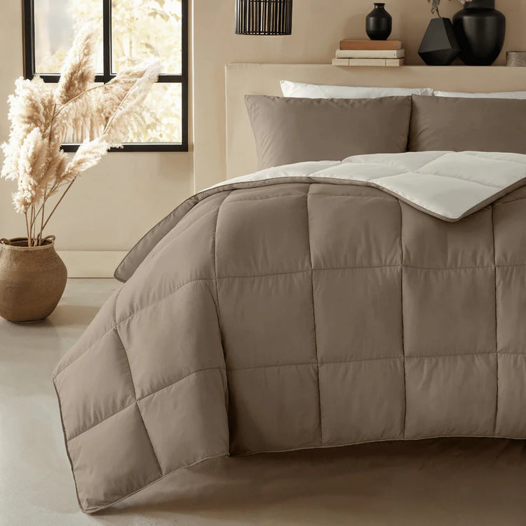Een bed dat staat in een slaapkamer en is opgemaakt met een dekbed van Zelesta.