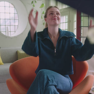 Linda zit in een oranje stoel en vangt een pakketje